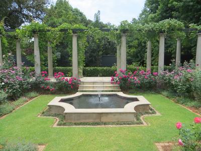 Garden design by Shirley Wallington — Raised pergola behind pond and rose garden